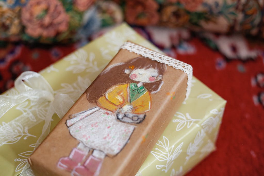 A beautifully wrapped gift box featuring a hand-painted illustration of a young girl with a camera.